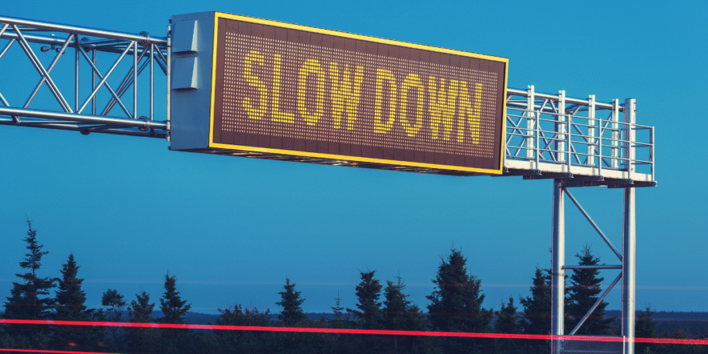 Picture of a sign board saying Slow Down